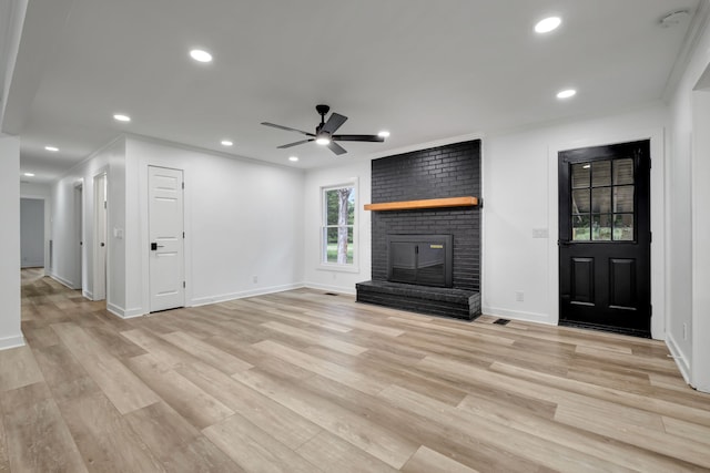 unfurnished living room featuring crown molding, light hardwood / wood-style flooring, ceiling fan, and a fireplace