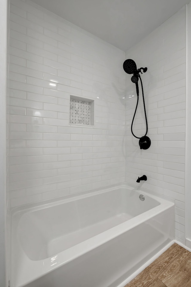 bathroom featuring tiled shower / bath and hardwood / wood-style floors