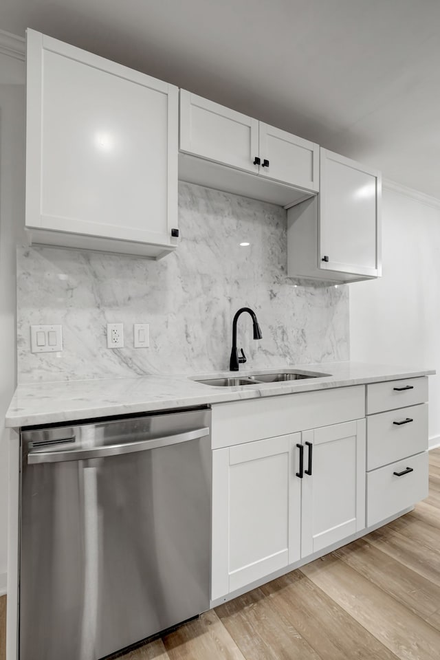 kitchen with stainless steel dishwasher, light wood-type flooring, and white cabinetry