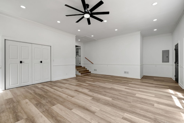 interior space featuring electric panel, light hardwood / wood-style flooring, ceiling fan, and crown molding