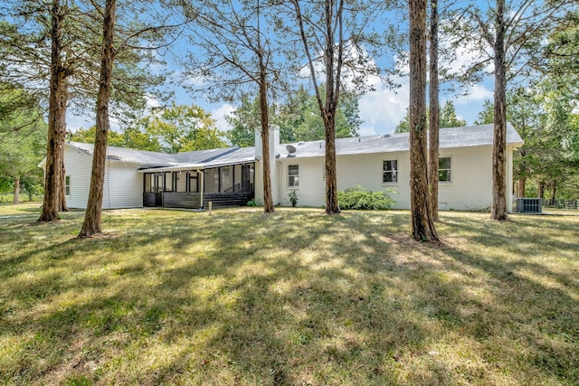 view of front of house with cooling unit, a front lawn, and a sunroom