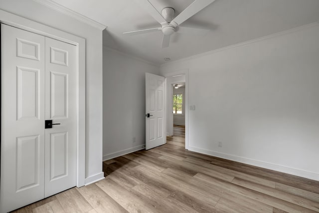 unfurnished bedroom with ornamental molding, light hardwood / wood-style flooring, ceiling fan, and a closet