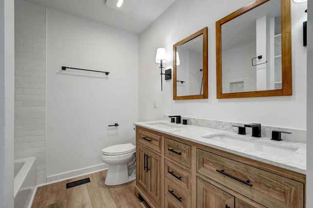 bathroom featuring wood-type flooring, toilet, and vanity