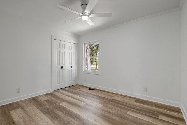 unfurnished bedroom featuring crown molding, a closet, ceiling fan, and light hardwood / wood-style floors