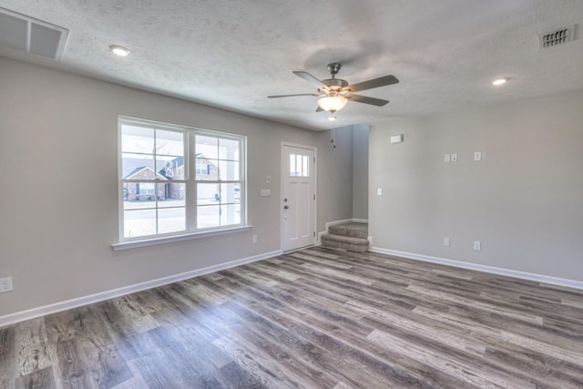 interior space featuring ceiling fan, hardwood / wood-style floors, and a textured ceiling