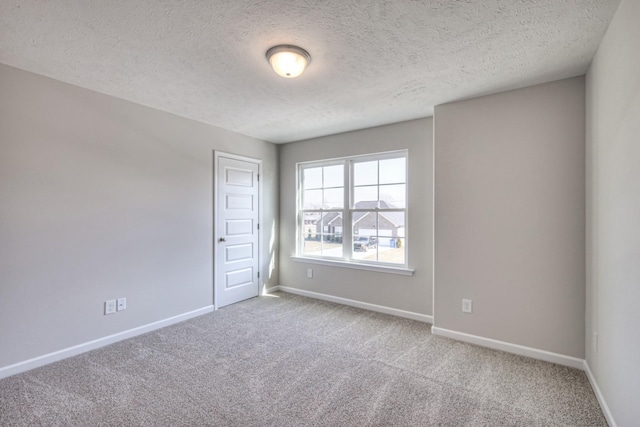 carpeted spare room with a textured ceiling