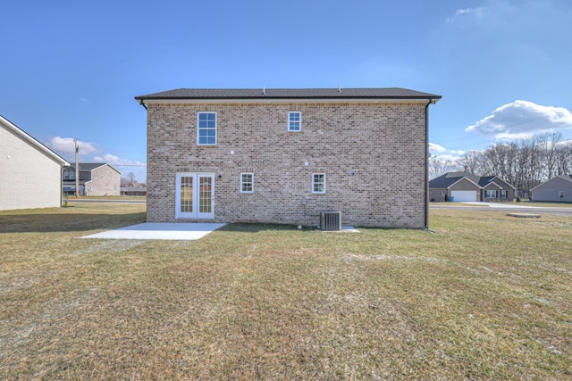 back of property with a patio, a yard, and french doors