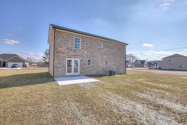 rear view of house featuring cooling unit, a yard, a patio area, and french doors