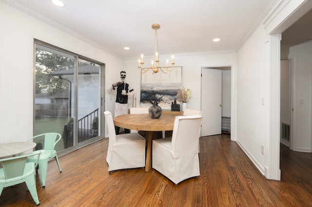 dining area featuring crown molding, dark wood-type flooring, and an inviting chandelier