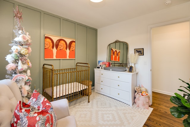 bedroom featuring a crib and wood-type flooring