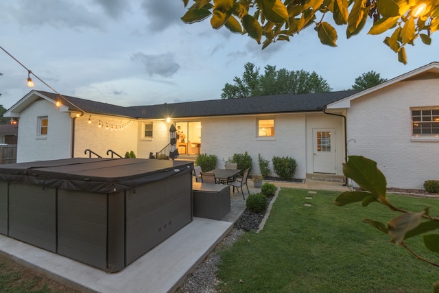 view of front of house featuring a front yard, a hot tub, and a patio