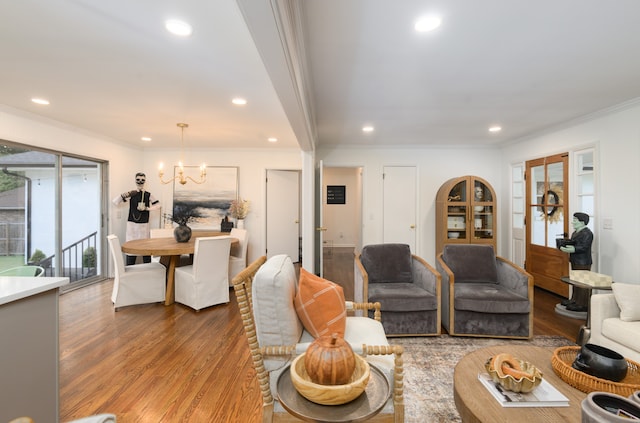 living room with hardwood / wood-style floors, a chandelier, and ornamental molding