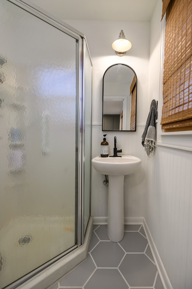 bathroom with an enclosed shower and tile patterned flooring