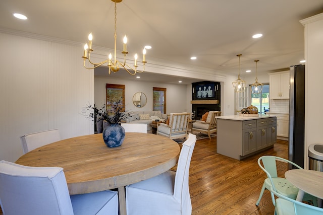 dining space with crown molding, a notable chandelier, and dark hardwood / wood-style flooring