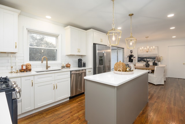 kitchen with a kitchen island, stainless steel appliances, white cabinetry, and dark hardwood / wood-style flooring