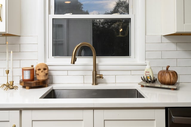 exterior details with white cabinets, backsplash, and sink