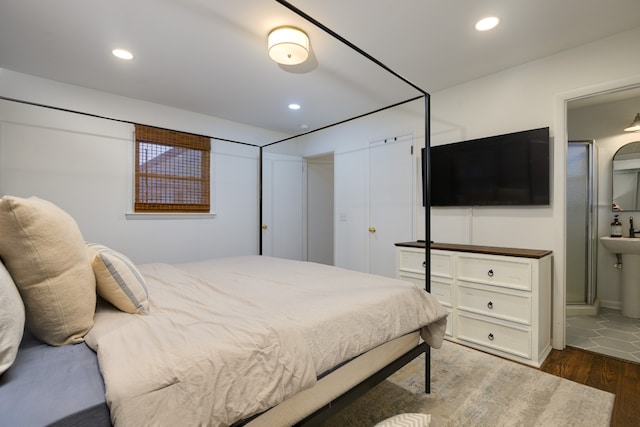 bedroom featuring connected bathroom and dark hardwood / wood-style floors