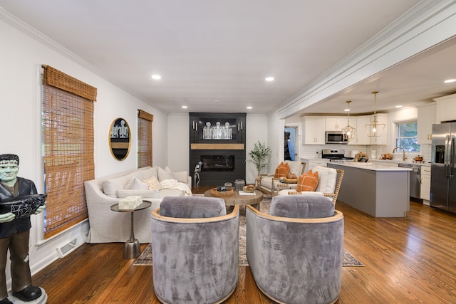 living room with ornamental molding, dark wood-type flooring, and a healthy amount of sunlight