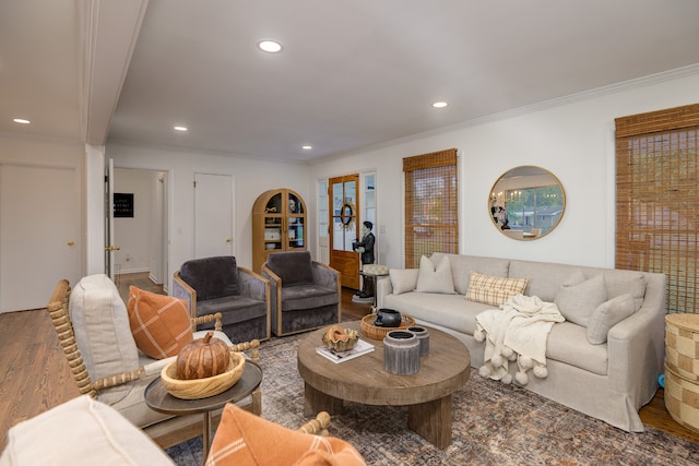 living room with a wealth of natural light, crown molding, and hardwood / wood-style flooring