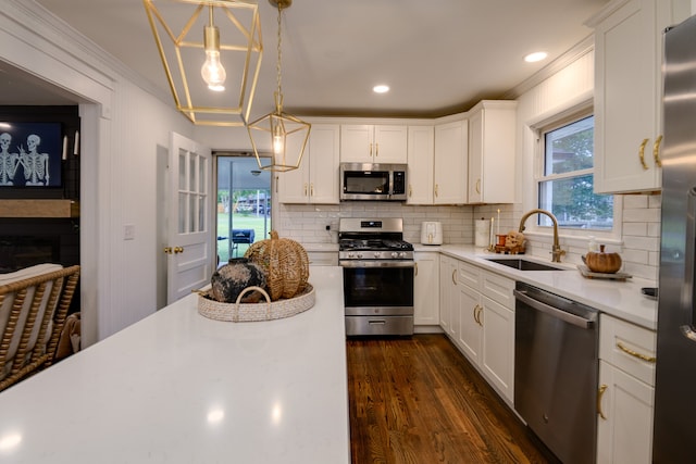 kitchen with dark hardwood / wood-style flooring, backsplash, stainless steel appliances, sink, and white cabinetry