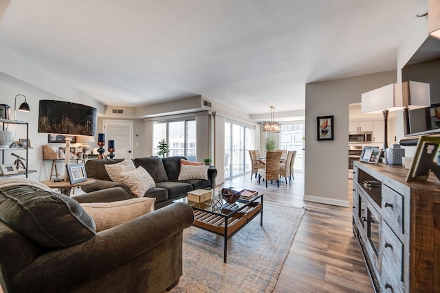 living room with an inviting chandelier and hardwood / wood-style flooring