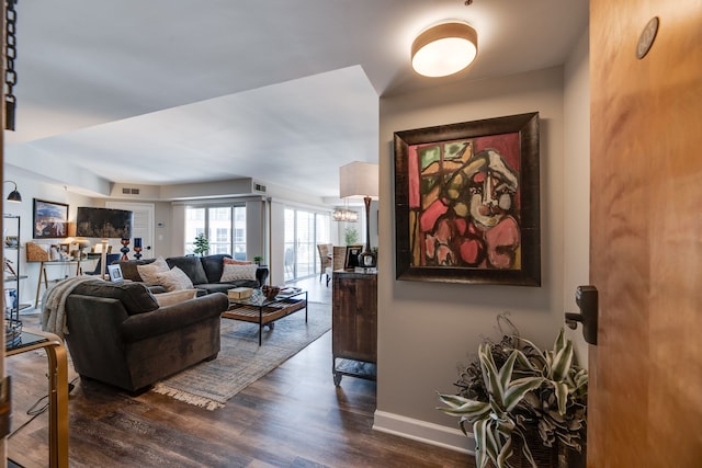 living room featuring dark wood-type flooring and a chandelier