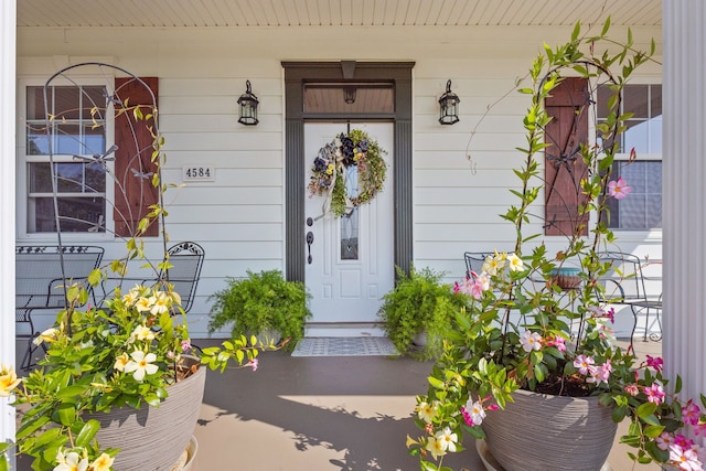 view of exterior entry featuring covered porch