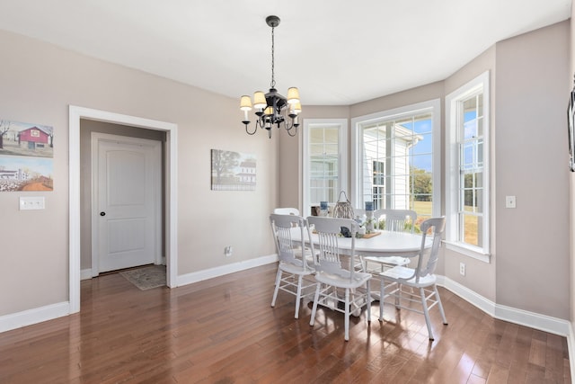 dining area with dark wood-type flooring and a notable chandelier