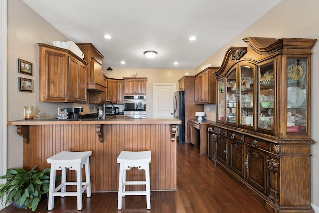4584 S Mill Ln, Cross Plains, TN 37049 - kitchen with a peninsula, freestanding refrigerator, a breakfast bar, premium range hood, and dark wood finished floors