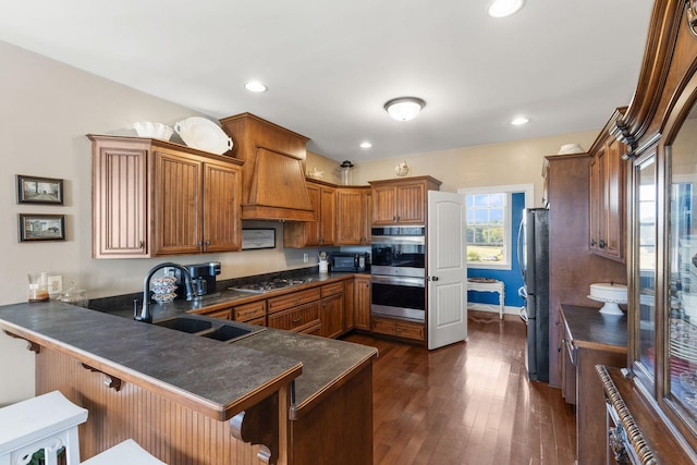 4584 S Mill Ln, Cross Plains, TN 37049 - kitchen with dark countertops, appliances with stainless steel finishes, a peninsula, brown cabinets, and recessed lighting