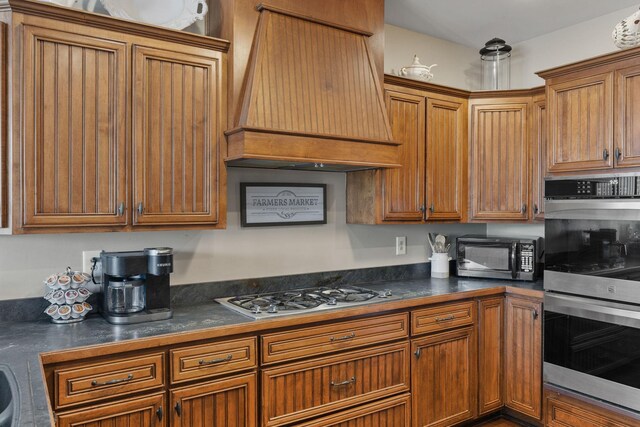 4584 S Mill Ln, Cross Plains, TN 37049 - kitchen with premium range hood, stainless steel double oven, black microwave, gas stovetop, and dark countertops