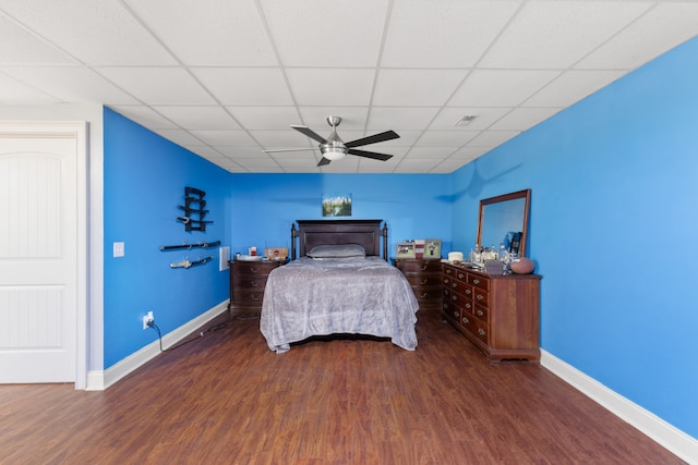 bedroom featuring ceiling fan, dark wood-type flooring, and a paneled ceiling