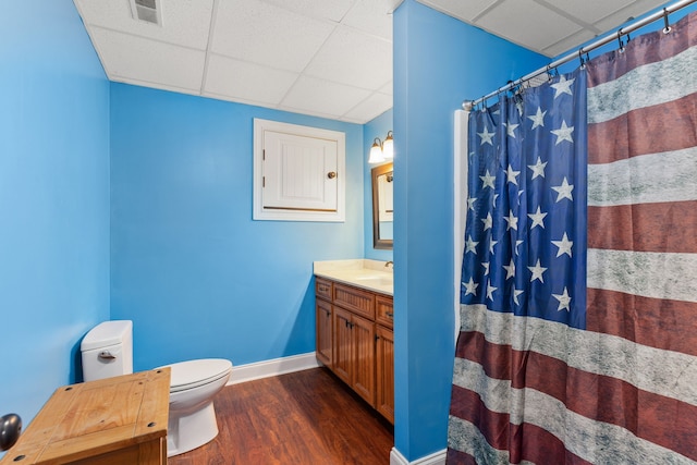 bathroom featuring hardwood / wood-style flooring, a paneled ceiling, a shower with shower curtain, vanity, and toilet