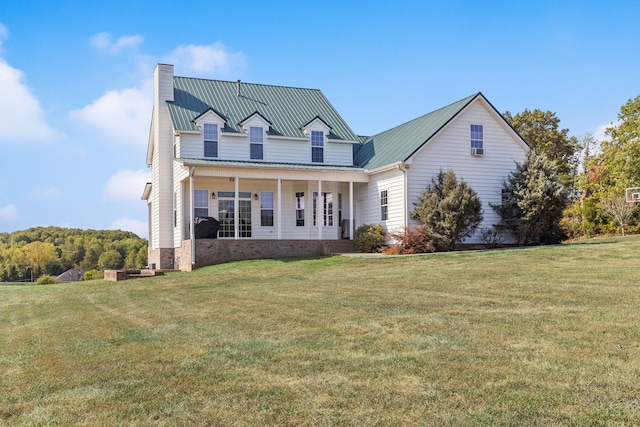 rear view of house featuring a porch and a yard