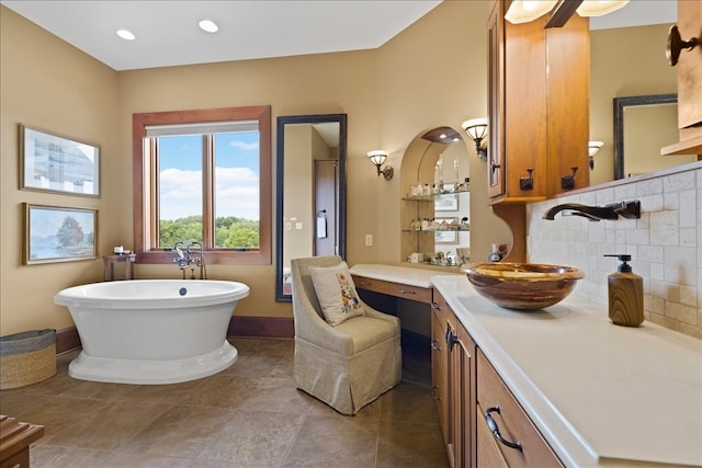 bathroom featuring a tub to relax in, vanity, backsplash, and tile patterned floors