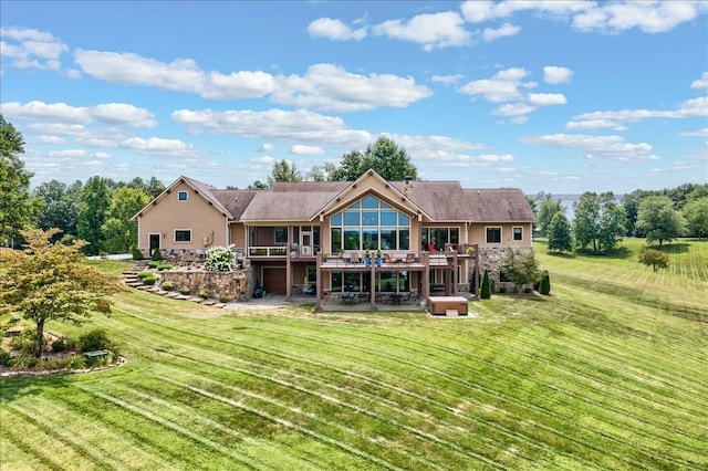 rear view of property featuring a lawn and a deck