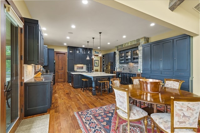 dining space featuring hardwood / wood-style flooring and wet bar