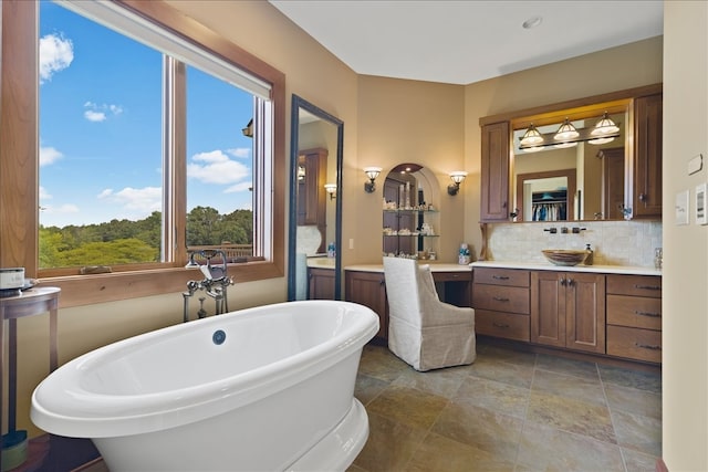 bathroom with vanity, a bath, and decorative backsplash