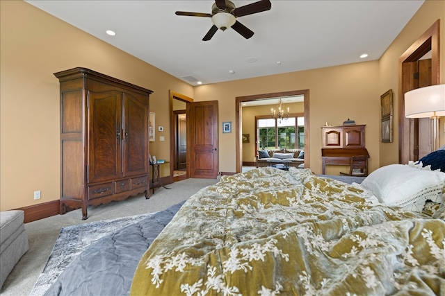 carpeted bedroom with ceiling fan with notable chandelier