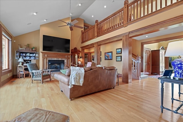 living room with light wood-type flooring, high vaulted ceiling, and ceiling fan