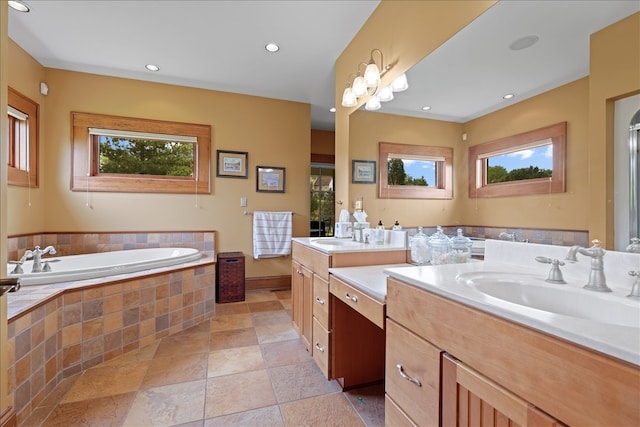 bathroom featuring vanity, plenty of natural light, a relaxing tiled tub, and tile patterned floors