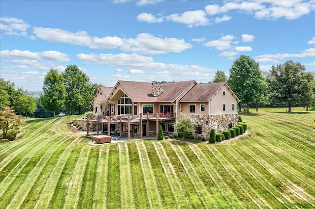 rear view of property featuring a yard and a wooden deck