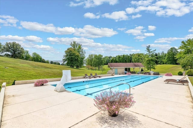 view of swimming pool with a lawn, an outdoor structure, and a patio area