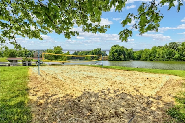 view of home's community with volleyball court, a water view, and a yard