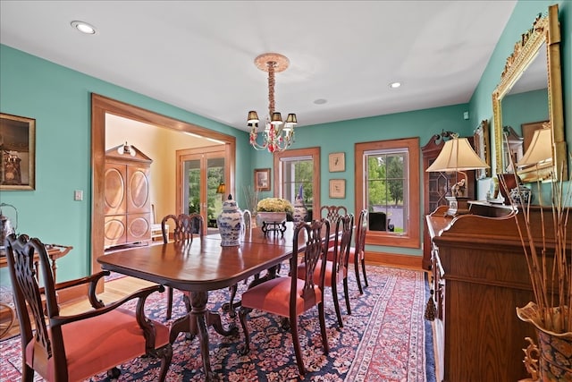 dining area featuring wood-type flooring and an inviting chandelier