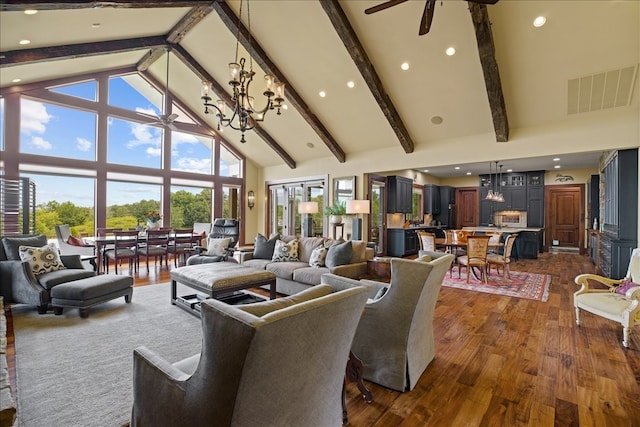 living room with ceiling fan with notable chandelier, beamed ceiling, high vaulted ceiling, and dark hardwood / wood-style floors