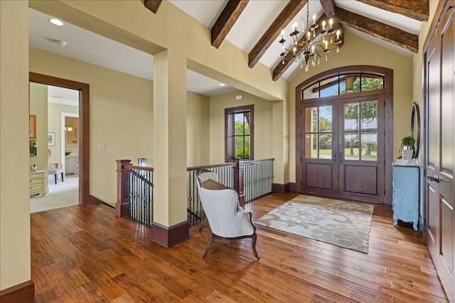 foyer with hardwood / wood-style floors, a chandelier, and lofted ceiling with beams