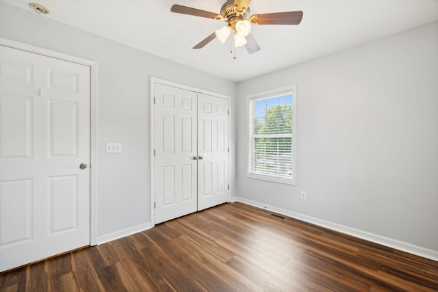 unfurnished bedroom featuring dark wood-type flooring and ceiling fan