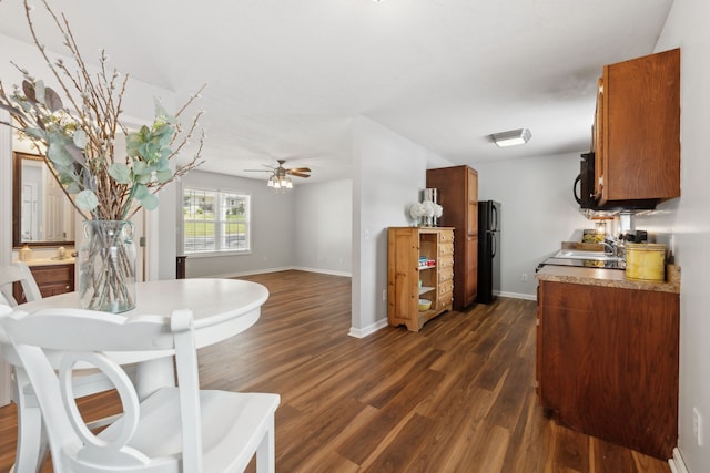 interior space featuring black appliances, ceiling fan, and dark hardwood / wood-style floors