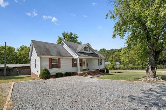 view of front of property featuring covered porch, a front lawn, crawl space, and a shingled roof